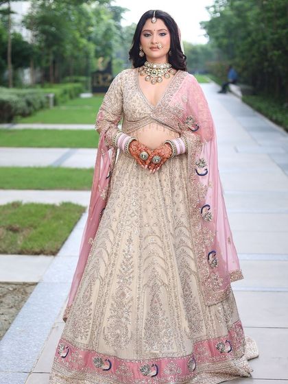 Say 'I do' in style with this gorgeous ivory and pink bridal lehenga. The intricate silver embroidery and pink border make it a stunning choice for a modern bride.