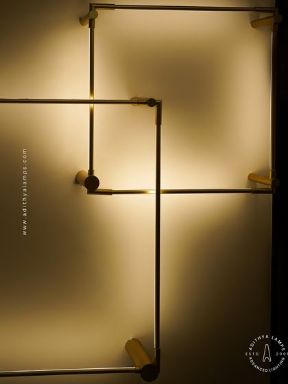 This geometric wall light is a study in minimalist elegance. Inspired by clean lines, the square-shaped fixture is mounted on a wall, creating a warm, ambient glow that is both a light source and a piece of modern art.