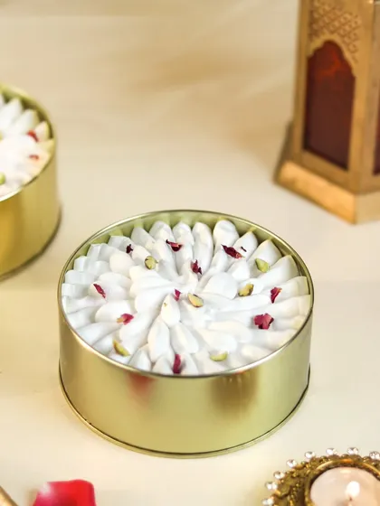 My Rose Milk Tres Leches cake, presented in its golden tin, topped with whipped cream and rose petals.