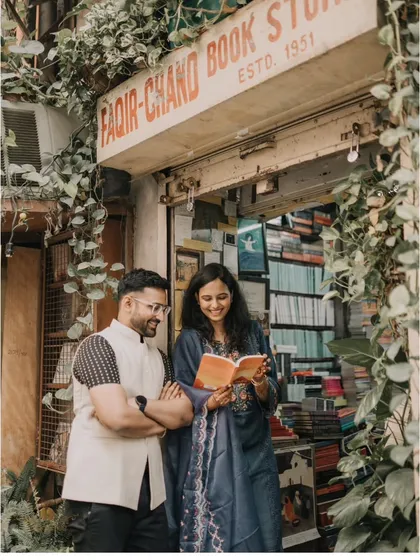 A candid moment captured outside a charming Khan Market bookstore. This style is perfect for urban couples, telling a story that feels authentic, personal, and rooted in the city you love.