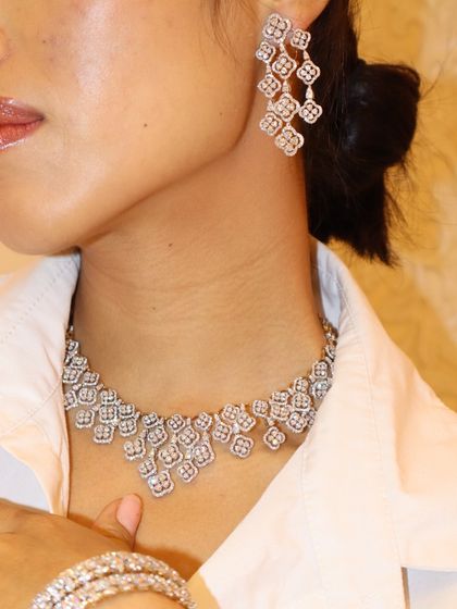 Another angle of the iced-out diamond necklace and chandelier earrings, showing how they beautifully frame the face.
