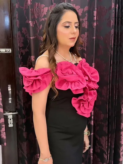 Another angle of the elegant black gown look. The soft waves in her hair and the glowing makeup create a sophisticated vibe.
