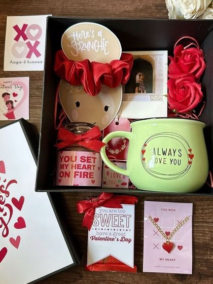 A Valentine's Day box filled with love. This hamper includes a "You Set My Heart On Fire" candle, a cute mug, a heart necklace, and other romantic tokens of affection.