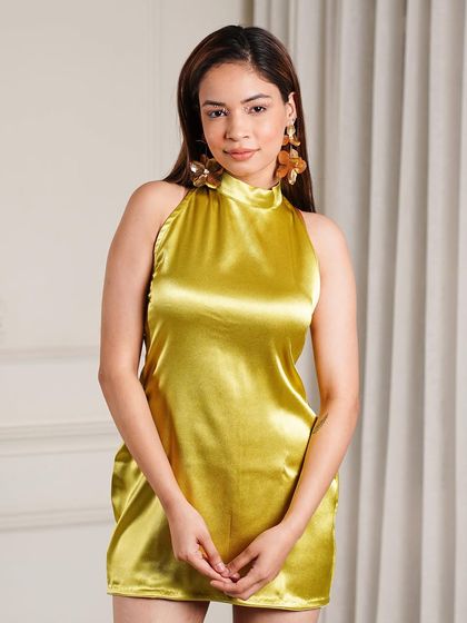 This look features a lime green satin halter dress, styled to feel fresh and modern. The focus is on the fabric's sheen and the simplicity of the silhouette, making it a great shot for e-commerce.