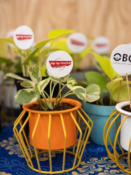 A vibrant orange metal pot with a stand, ready as a gift for a pop-up market. These small, colourful gifts are always a hit.