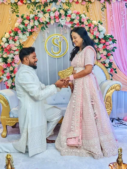 A classic engagement proposal shot on stage, with the groom-to-be on one knee. The floral arch and elegant seating create a perfect backdrop for this timeless moment.