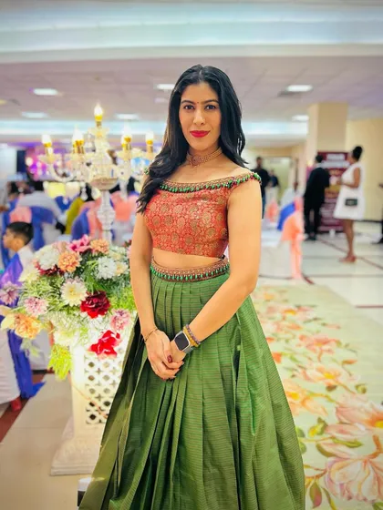 A heartwarming transformation. We took our client's mother's traditional saree and repurposed it into this stylish off-shoulder crop top and pleated lehenga skirt. It’s a beautiful way to honor family heritage while creating a new, modern look.