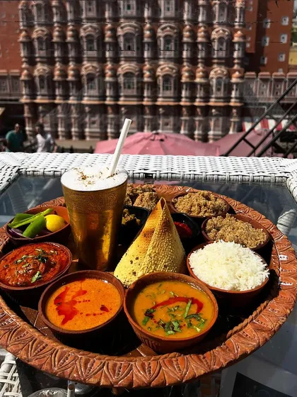 Food photography is not just about the dish, it's about the story. Here, a traditional Rajasthani thali is captured at The Tattoo Cafe, with the iconic Hawa Mahal creating a stunning, unforgettable backdrop that connects the food to its culture.