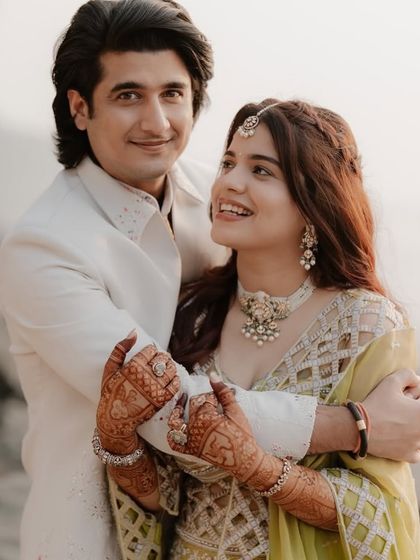 A lovely portrait of the couple embracing, the bride's detailed mehndi adding to her overall look.