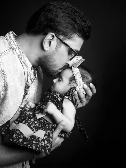 A tender black and white moment of a father kissing his baby's forehead. These unposed, candid-style shots are perfect for capturing genuine emotion.