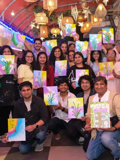 Look at this amazing group of new artists. My workshops bring people together for a fun, social, and creative experience. Everyone proudly holds up their unique floral canvas painting, a beautiful reminder of a day filled with laughter and art.