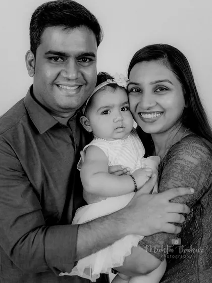 The same family portrait in timeless black and white, emphasizing the emotion and connection between the parents and their baby.