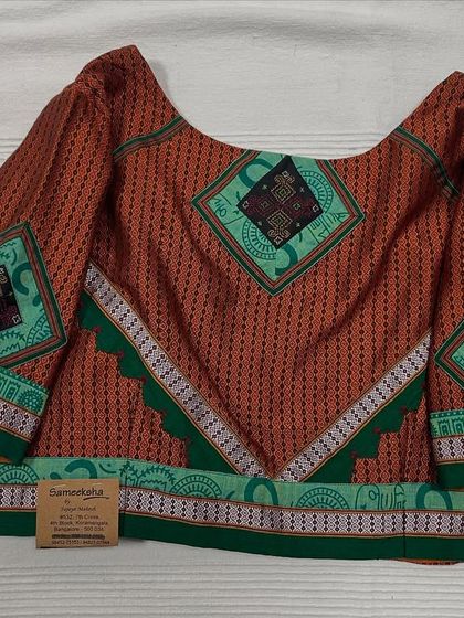 A beautiful ready-made blouse combining different fabrics and patterns, with Kasuti embroidered patches adding a touch of handcrafted detail.