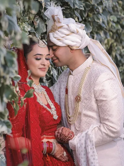 An intimate and romantic close-up of the couple, their foreheads touching in a moment of quiet connection on their wedding day.