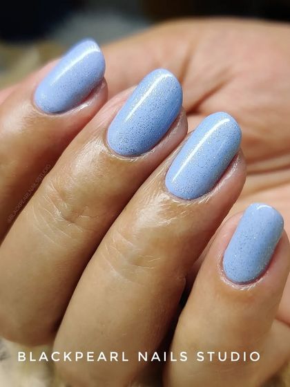 A close-up of the light blue glitter nails, showing the smooth application and perfect shaping achieved with the BIAB and Russian Manicure technique.