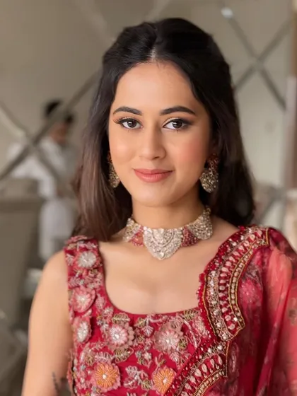 A beautiful engagement look with a simple half-updo and soft waves, adorned with delicate red flowers.
