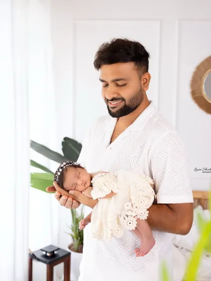A proud father holds his tiny newborn, a beautiful portrait showcasing their immediate bond.