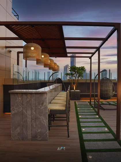 The rooftop bar and lounge area in Lower Parel at sunset. This space was designed to provide a sophisticated setting for socializing while enjoying panoramic views of the Mumbai skyline.