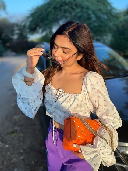 A cute and casual look with a floral puff-sleeve top and purple trousers, perfect for a sunny day.