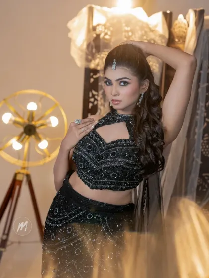 A high-fashion, glamorous look featuring a black sequined outfit. The makeup is bold and dramatic, with a strong smokey eye and sculpted cheekbones.