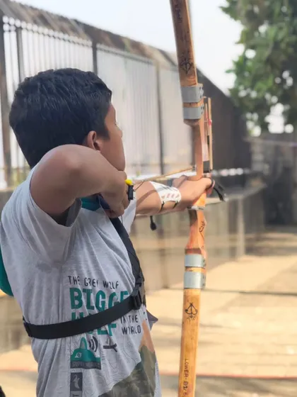 An archer in mid-shot, demonstrating the form and technique he has learned.