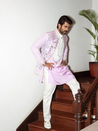 The full look. The embellished jacket is layered over a simple kurta and white trousers, letting the statement piece shine while maintaining a clean, cohesive feel.