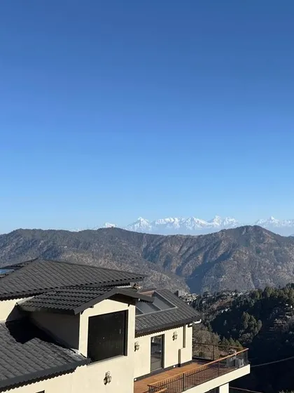 The snow-capped peaks of the Himalayas seen from the 'Soulitude' project site. The architecture is oriented to maximize these breathtaking views, making the landscape the true hero of the design.