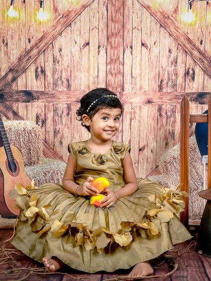 A full-length shot of the charming barnyard theme, showing the little girl in her beautiful dress surrounded by rustic decor.