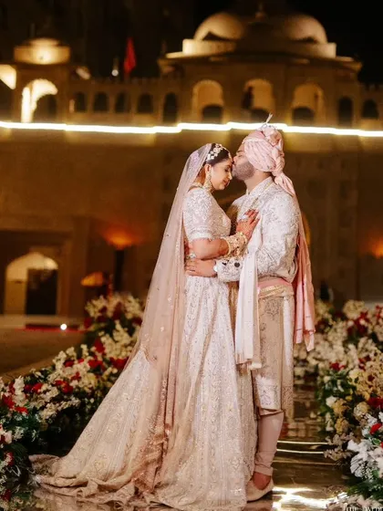 Amidst the grand celebrations, I focus on creating intimate, picture-perfect moments for you and your partner. This quiet embrace against the magnificent backdrop of a palace at night is a memory frozen in time.