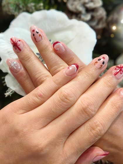 Let your nails sparkle with the magic of Christmas. This design features delicate reindeer, gift bows, and snowflake art.