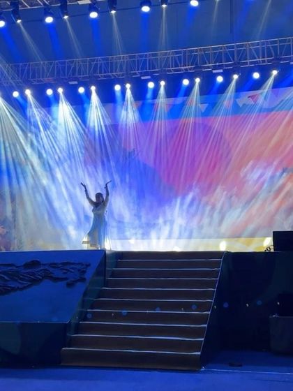 A wide shot of the stage during the Paani Foundation's dance drama, showing the beautiful lighting and set design.