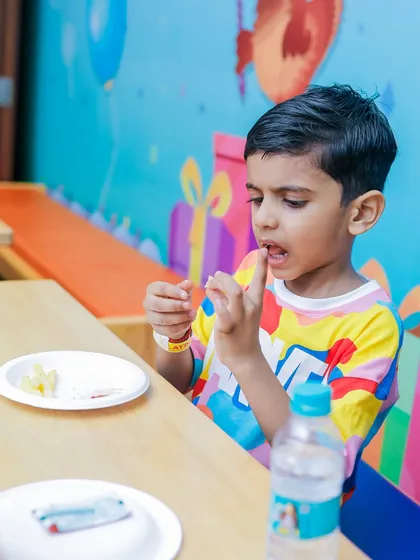 A young boy enjoying a snack during his playtime break.