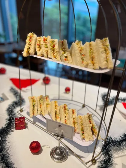 Classic egg salad sandwiches served in a tiered stand for the Christmas high tea. This elegant presentation is perfect for corporate events and formal gatherings.