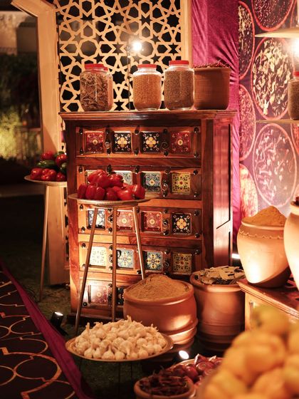 More details from the spice market, with a backdrop of jali work. The combination of rustic terracotta pots, a painted chest, and fresh produce created a rich, layered, and authentic scene.