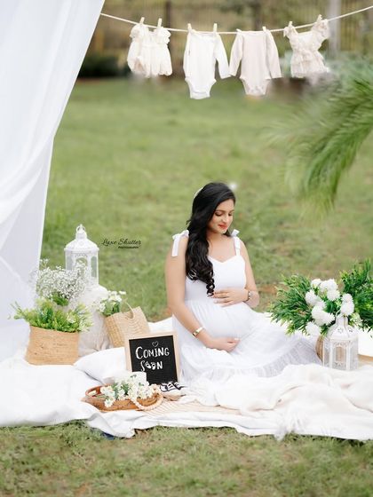 A lovely picnic setup for an outdoor shoot. The "Coming Soon" sign and the line of baby clothes create a perfect scene for announcing your pregnancy.