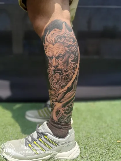 A full view of the Poseidon leg sleeve, showcasing the god of the sea amidst swirling waves. The raw, unedited photo highlights the smooth shading and realistic texture achieved in this mythological piece.