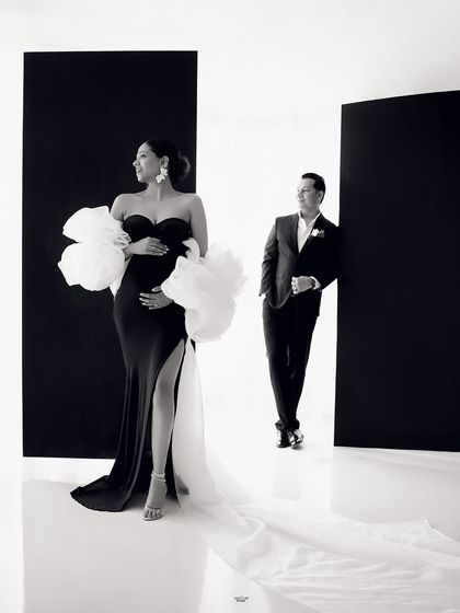 A dramatic and stylish black and white portrait. The composition, with the mamma in the foreground and her partner in the back, creates a cool, editorial feel.