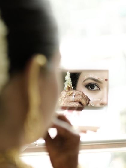 A creative shot capturing the reflection of her stunning eye makeup in a mirror. The precision of the liner and the delicate dots are key to this look.