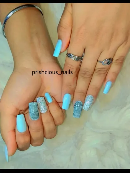 Another shot of the jewel-like blue and silver manicure on long, square-shaped acrylics.