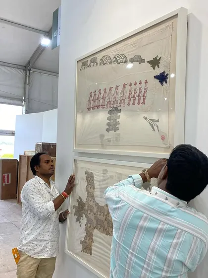 The team carefully lifting one of Archana Hande's large textile pieces into place.