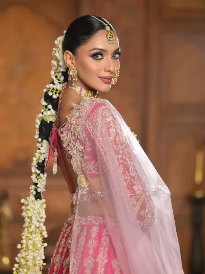 A beautiful shot from the back, showcasing the stunning detail of the long, floral braid and the intricate design of the blouse.