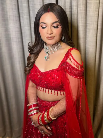 A beautiful portrait of the bride, with her eyes closed, showcasing her glamorous makeup and the soft texture of her wavy hair.