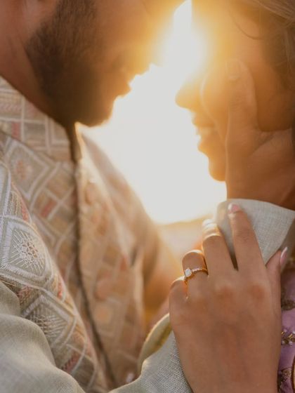 A close-up on the engagement ring as the couple shares an intimate moment. The focus on the hand and the ring tells a story of commitment against a backdrop of love.
