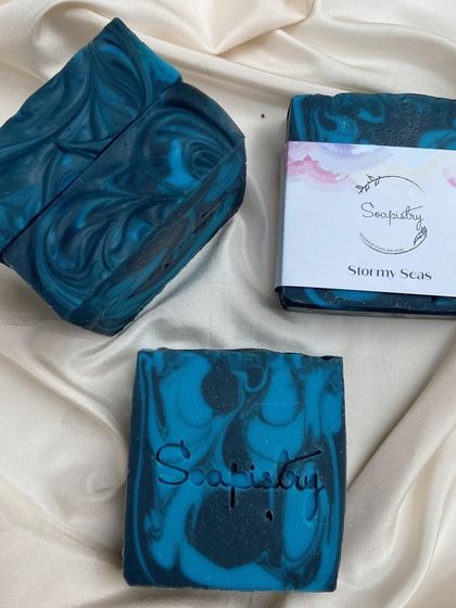 The "Stormy Seas" soap bar, with its deep blue and black swirls, has a classic aromatic fragrance with notes of bergamot, rosemary, and cedar.