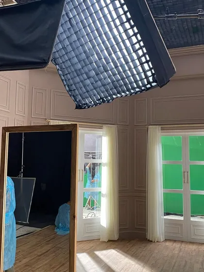 An Aladdin Fabric 350 with a soft grid is used here to provide controlled lighting for a TVC shoot. The greenscreen visible outside the window indicates a visual effects shot, requiring precise separation between the foreground and background lighting.
