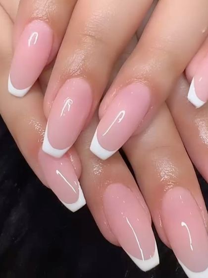 A close-up of a perfectly executed classic French manicure on long, coffin-shaped extensions.