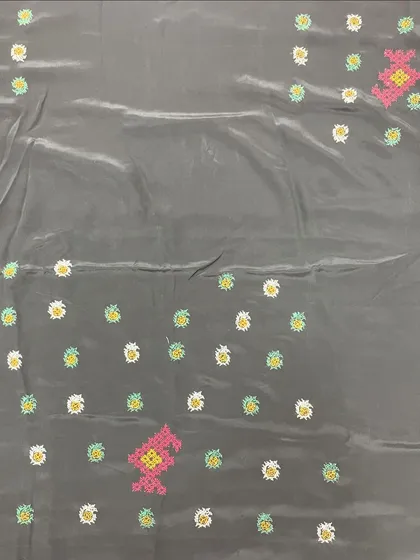 A grey silk saree with scattered floral butis and larger motifs. The pop of pink adds a contemporary feel to the traditional cross-stitch embroidery.
