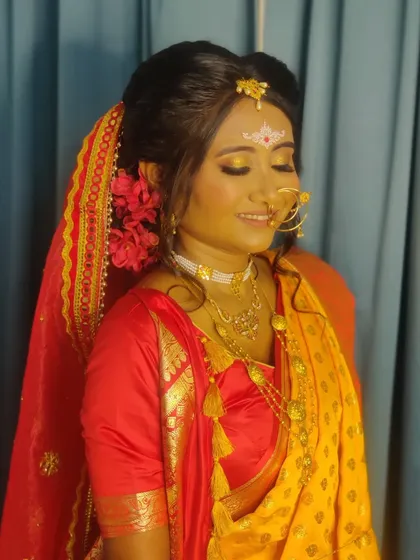 The quintessential Bengali bride, with her expressive eyes and traditional 'sholar mukut' design on her forehead.
