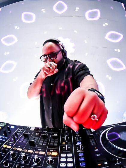 A fisheye lens view of me at the console, surrounded by a tunnel of light visuals. This is the kind of immersive setup that defines my events.