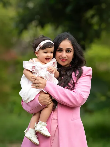A happy portrait of a mom and her baby girl. The natural light and green surroundings create such a fresh and vibrant photo.